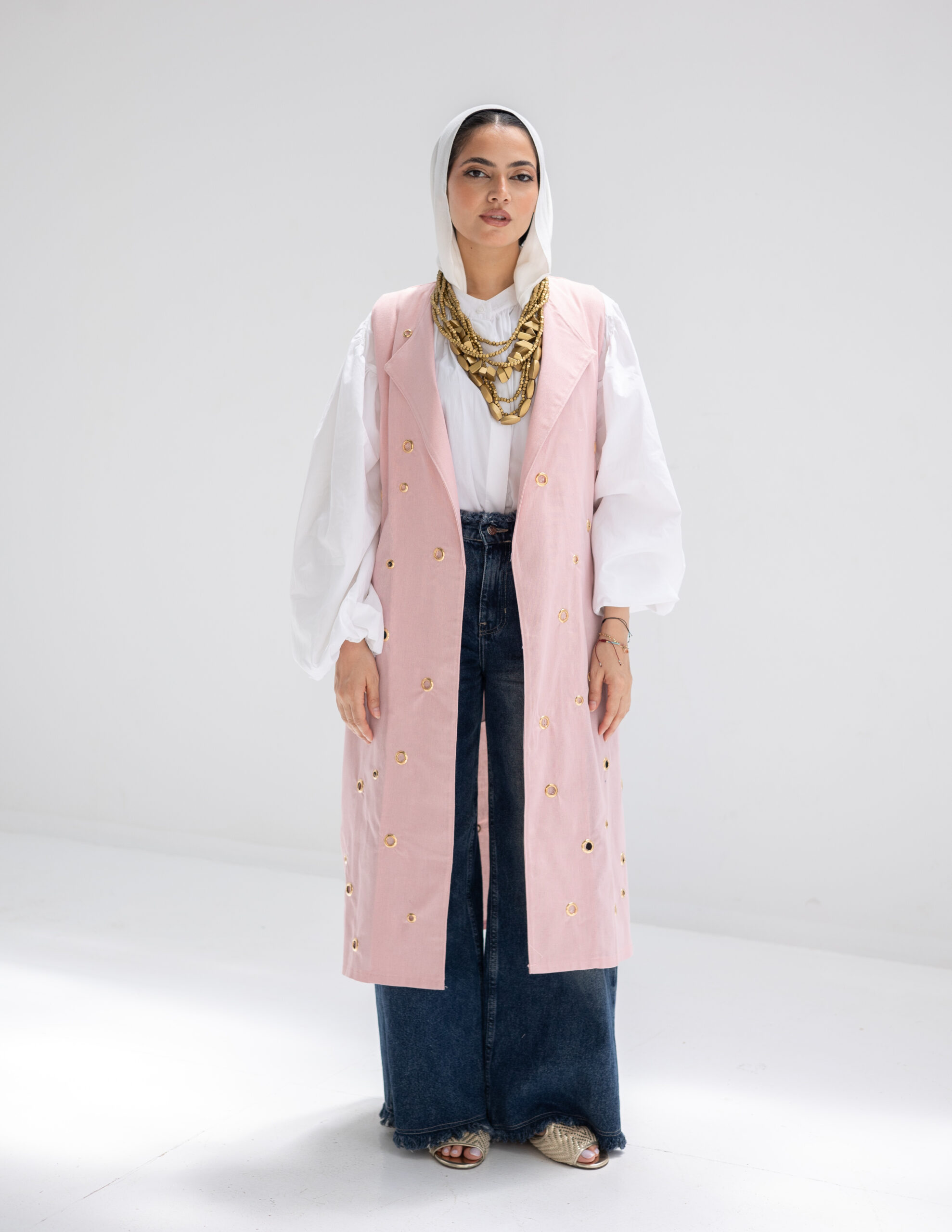 Part of Everyday Grace – Wave II, the Aura Vest is a refined layering piece crafted from airy linen and elevated with delicate metal ring accents. These subtle details bring a modern edge to its clean silhouette—blending softness with quiet strength. Light, structured, and effortlessly elegant, Aura transitions seamlessly from day to evening, offering a graceful finish to any look.